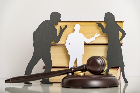 paper cutouts of couple fighting in front of gavel