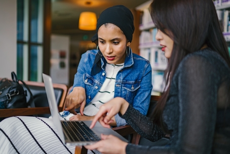 two people looking over digital assets on a laptop