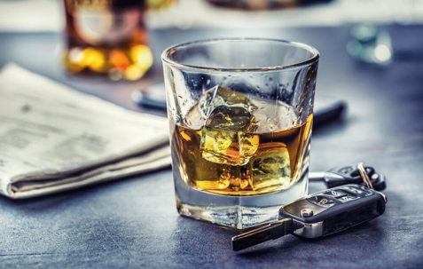 Glass of whiskey next to keys