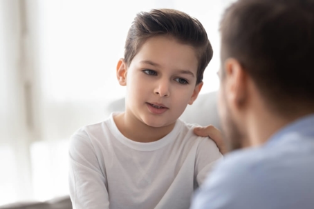 A boy sitting across from his father.